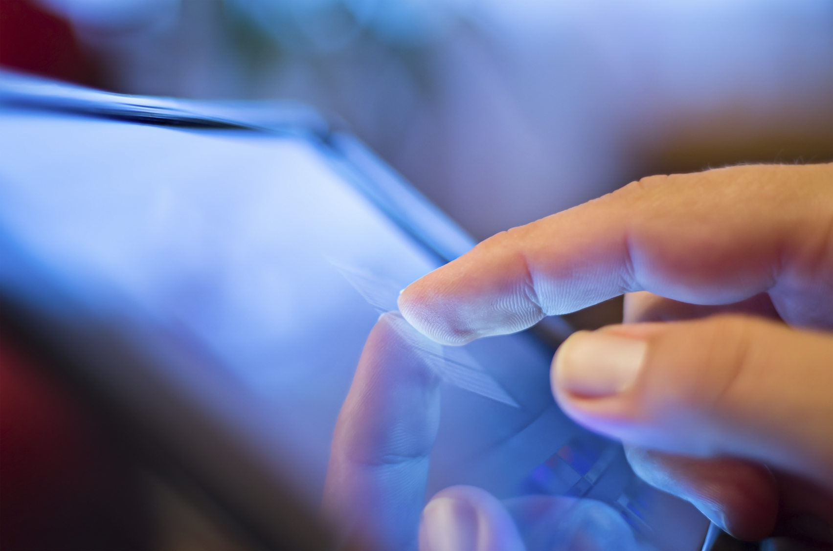 closeup of finger touching screen  on tablet-pc with shallow depth of field